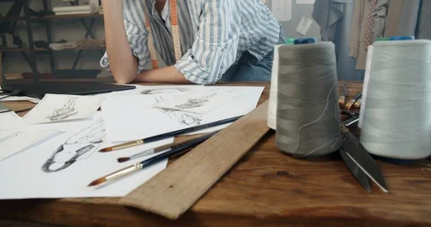 Close-up shot of a clothes designer redrawing beautiful sketches from paper to Video stock 128083979