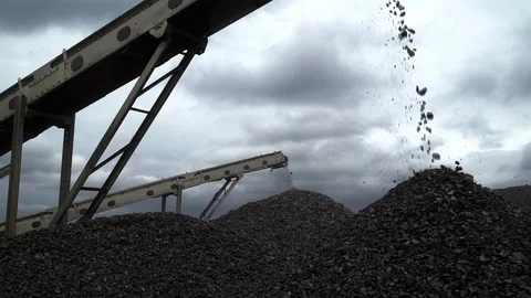 A close-up shot of coal chunks falling from the belt conveyors at the coal mine Stock Footage 101504703