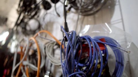 Close Up Shot of Coiled Electrical Wires and Cables Hanging on Workshop Wall Stock Footage 337921478