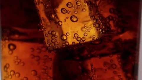 Close up shot of Cola on ice in slow motion Stock Footage