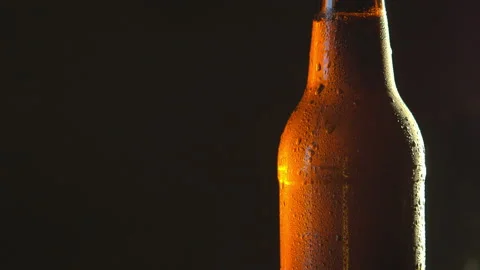 Close up shot of cold beer in dark bottle with water droplets Stock Footage 100768118