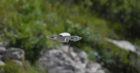 A close-up shot of a compact drone hovering in mid-air, surrounded by Stock Footage 287702293