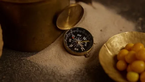 Close-up shot of a compass gadget displayed on a dark set with dramatic Stock Footage 345286471