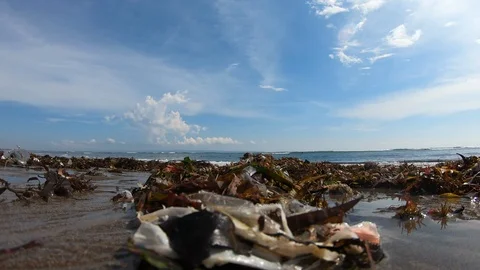 Close up shot of compiled garbage on polluted beach near sea on sunny day, Bali Stock Footage 140288185