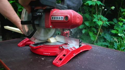 A close up shot of a compound miter saw cutting a 動画素材 201309474