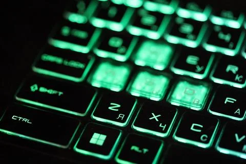 A close-up shot of a computer keyboard with green lights, ideal for tech-related Stockfoto's