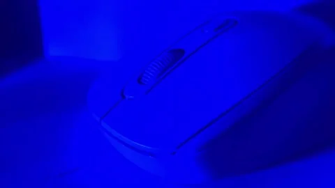 Close-up shot of a computer mouse under colored studio lighting on a clean surfa Stock Footage 326336055
