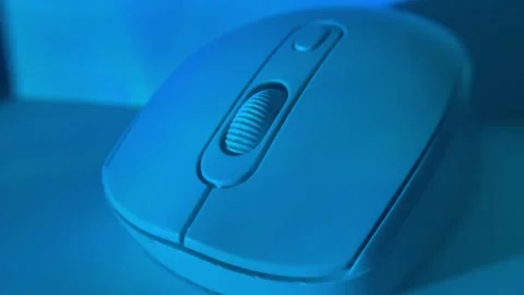 Close-up shot of a computer mouse under colored studio lighting on a clean surfa Stock Footage 326336102