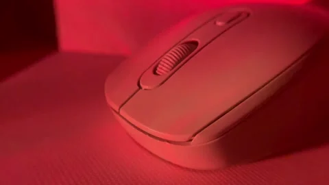 Close-up shot of a computer mouse under colored studio lighting on a clean surfa Stock Footage 326336104