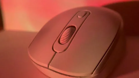 Close-up shot of a computer mouse under colored studio lighting on a clean surfa Video stock 326336176