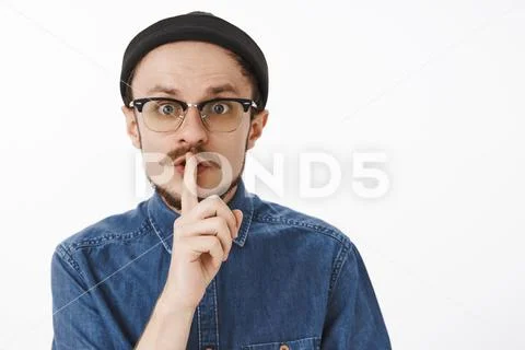 Close-up shot of concerned panicking handsome guy with beard in black beanie and Stock Photos