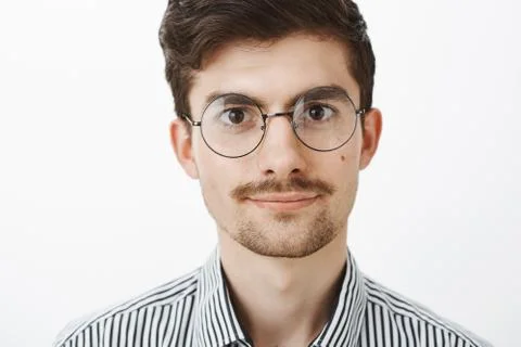 Close-up shot of confident smart creative guy with beard and moustache in round Stock-Fotos