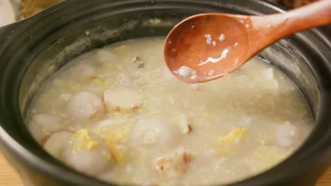 Close-up shot of congee simmered with Chinese yam, egg, lychee and rice. Stock Footage 342468559