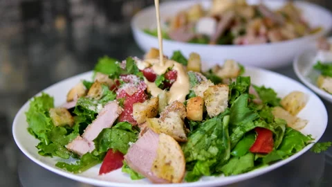 Close up shot of cooking Caesar salad inside deep cooking bowl. Chef cooking 스톡 동영상 277442041