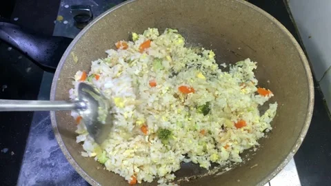 Close-up shot of a cooking fried rice in a hot wok on a stove Stock Footage 296734089