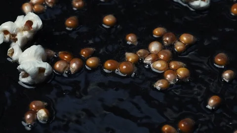 Close-up shot on cooking popcorn in a pan with hot oil at 100 fps Stock Footage 112561622