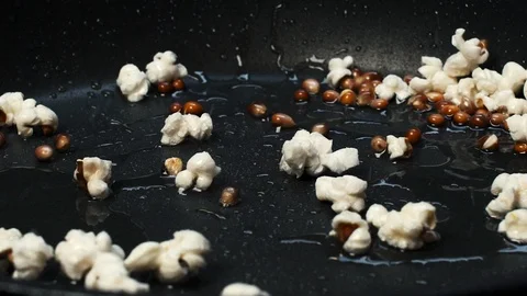 Close-up shot on cooking popcorn in a pan with hot oil at 100 fps Stock Footage 112562904