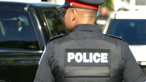 Close shot of cop's back before turning focus to background police officers Stock Footage 141222328