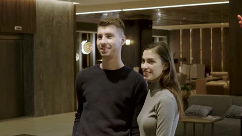 Close-up shot of couple checking in at receptionist in lobby of luxury hotel. 4K Stock Footage 89259785