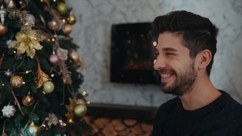 Close-up shot of a couple looking to each other. Christmas tree is on the Stock-Footage 104198957
