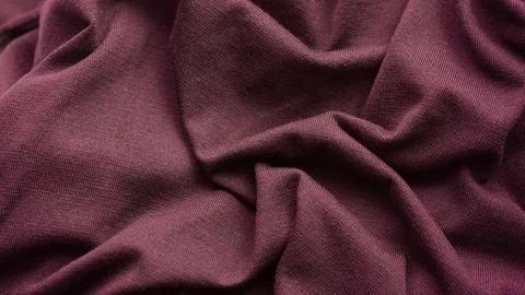 A close-up shot of a crumpled and soft maroon knitted fabric texture Stock Photos