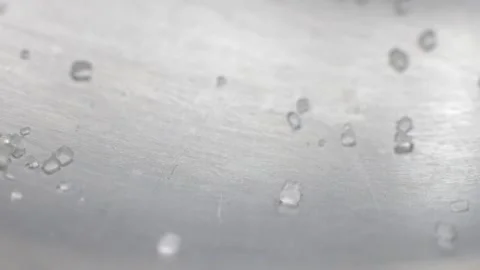 Close-up shot of crystals of sugar falling on a stainless steel surface of a spo Vídeo Stock 205518866