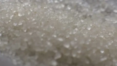 Close-up shot of crystals of sugar falling on a stainless steel surface Stock Footage 205518874