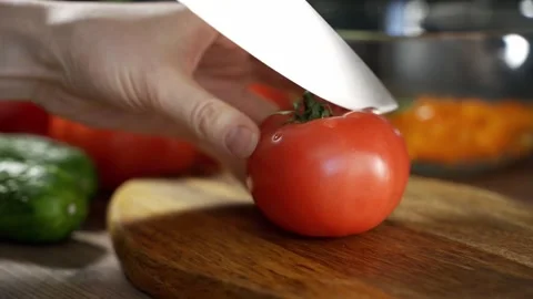 Close up shot of culinary master is cutting tomato to be prepared as a cooking Video stock 149753161
