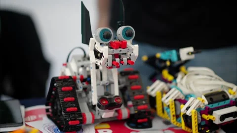 Close up shot of custom built toy robot with tracks and big eyes on table. Stock Footage 339373220