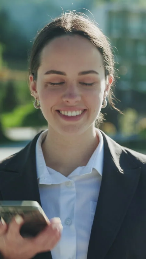 Close-up shot of cute friendly-looking young Caucasian woman holding smartphone Vídeo Stock 279720342