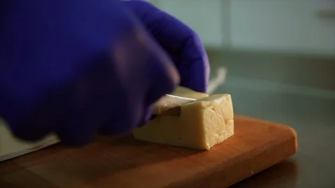 Close up shot. Cutting cheese. Knife slices cheese in cubes Vidéo 104130956