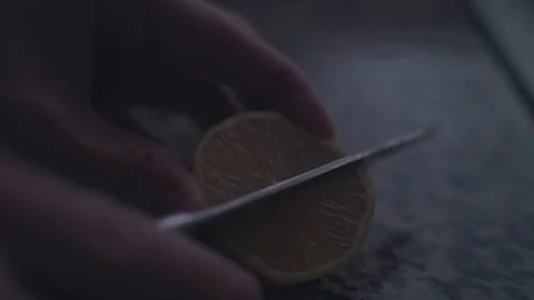 Up close shot cutting a lemon half into wedges. 4k UHD Stock Footage 89491025