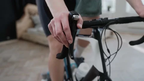Close shot of a cyclist changing speed on an exercise bike, training at home Stock-Footage 171116397