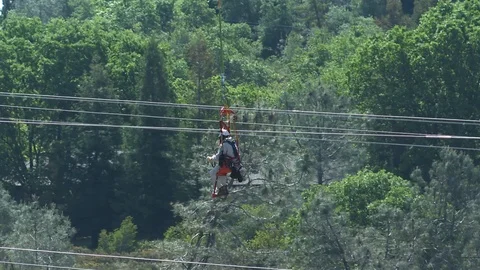 Close up shot of daring high voltage lineman dangling from a helicopter Stock Footage 127220515