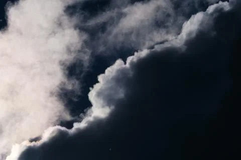 Close shot of a dark cloud with white corners in a sky Stock Photos