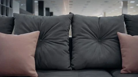 Close-up shot of a dark gray couch with red decorative pillows. 4k video Video stock 231508228