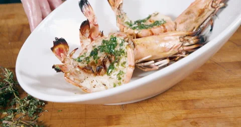 Close-up shot of delicious large grilled prawns with herbs and spices in a white Stock Footage 153235945