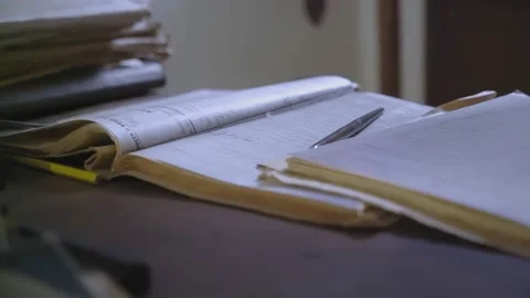 Close-up shot at desk level of a through papers, documents Stock Footage 205460703