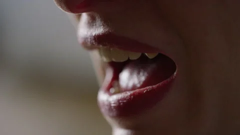 Close up shot of dimly lit lips of a young woman talking in conversation Stock-Footage 143754792