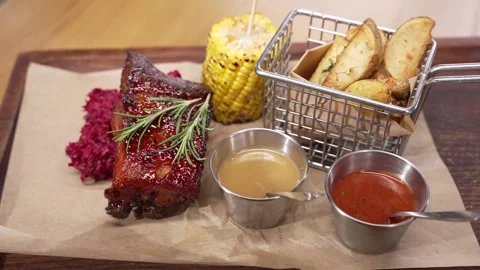 A close-up shot of a dinner table baked potato with vegetables and a juicy steak Stock Footage 244782411