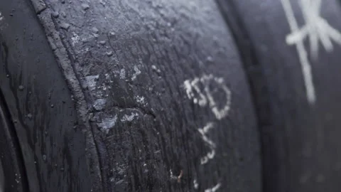 Close up shot of dirty worn racing slicks removed and placed on a tire Stock Footage 135055718