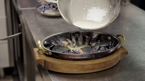 Close shot of dish cook prepares mussels baked in frying pan Stock Footage 76750288