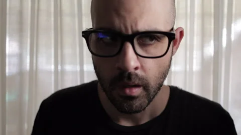 Close-up shot of a distressed man in dramatic lighting, breathing rapidly  Stock Footage 306846721