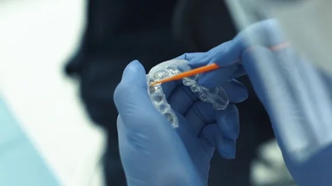 Close-up shot of doctors hands in gloves working with silicone mouth guard Stock Footage 70040714