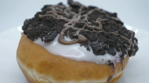 A close up shot of a donut with cookie grumble topping. Video stock 201211853