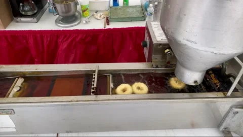 Close up shot of donuts being made by a donut machine at the fair Stock Footage 240056655