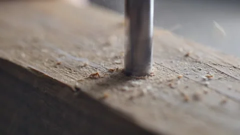 Close shot of drill bit drilling a hole in wood. flying wood chips and dust. Stock Footage 140976974