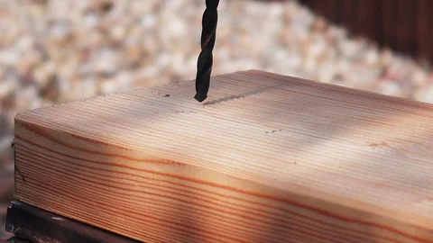 A close-up shot of a drill, drilling a hole into a piece of wood. Video stock 93798065