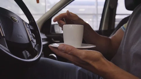 Close up shot: driver having some coffee from cup to keep him awake Stock Footage 94233554