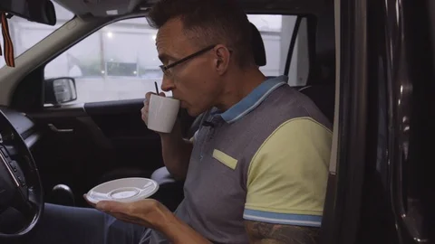 Close up shot: driver having some coffee from cup to keep him awake Stock Footage 94234003